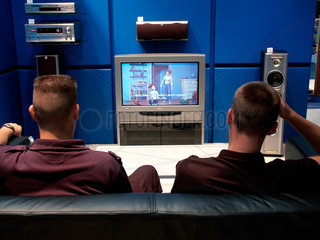 Berlin  zwei Besucher einer Ausstellung schauen Fernsehen