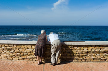 Santa Lucia  Italien  aelteres Paar steht an der Promenade und schaut aufs Meer