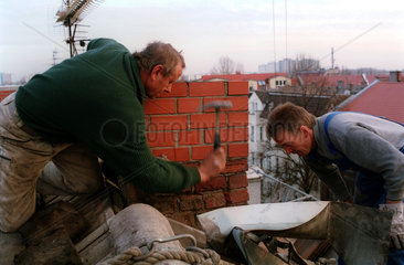 Zwei Schornsteinbauer bei der Arbeit
