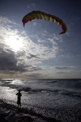 Kaegsdorf  Deutschland  Silhouette  Junge laesst einen Lenkdrachen am Meer steigen