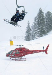 Skifahrer und Rettungshubschrauber im Schneegestoeber