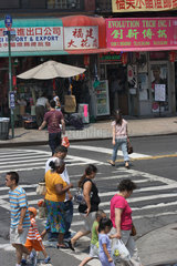 New York  USA  Passanten in Chinatown an einem Zebrastreifen