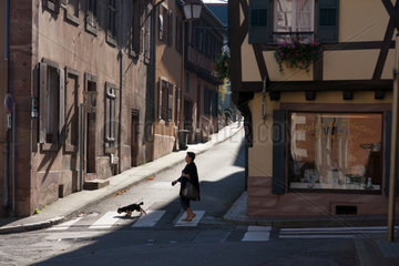 Zabern  Frankreich  eine Frau laeuft mit ihrem Hund durch die Strassen im Zentrum