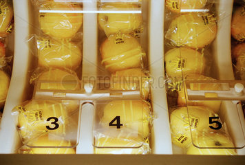 Einzeln verpackte gelbe Aepfel liegen in einem Automat