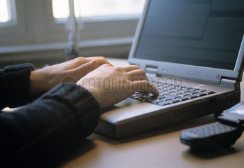 Nutzerin eines Notebooks an einem Schreibtisch