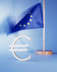 Das Eurozeichen vor einer EU-Flagge stehend