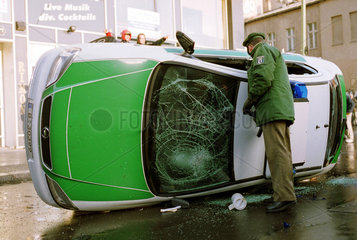 Ein Polizist vor seinem zerstoerten Funkwagen in Berlin