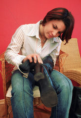Eine junge Frau putzt ihre Schuhe