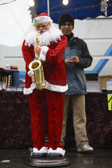 Paris  Frankreich  Haendler mit auf einem Saxophon spielenden Weihnachtsmann
