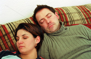 Mann und Frau schlafen auf der Couch