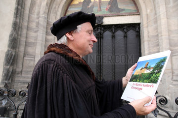 Wittenberg  Deutschland  Lutherdarsteller Bernhard Naumann mit einem Buch ueber Martin Luther