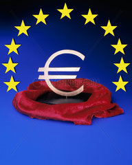 Der Euro auf einem Sockel unter rotem Samt  elf EU-Sterne im Halbkreis darueber