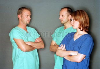 Gruppe von drei Medizinern mit verschraenkten Armen
