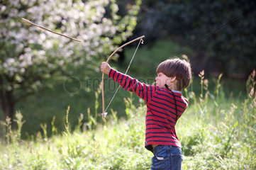 Carabietta  Schweiz  Junge spielt mit Pfeil und Bogen auf einer Wiese
