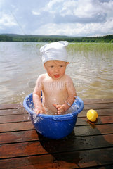 Kleinkind in einer Wanne am See