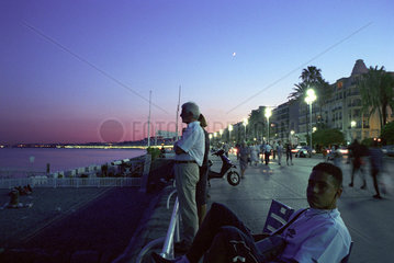 Menschen auf der abendlichen Seepromenade von Nizza