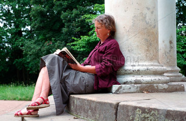 Dessau  Eine Frau liest  an eine Saeule gelehnt