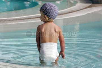 Pajara  ein kleines Kind in Windeln planscht in einem Swimmingpool