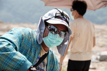 Macau  China  Mann mit Mundschutz  Basecap und Sonnenbrille