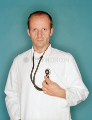 Ein Arzt hoert sich mit einem Stethoskop selbst ab