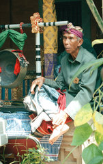Ein alter Mann in der festlichen Kleidung eines traditionellen Gamelanorchesters
