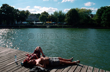 Berlin  Mann und Frau sonnen sich am Treptower Park