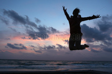 Pass A Grille  Vereinigte Staaten von Amerika  Silhouette  Frau macht einen Luftsprung bei Daemmerung am Strand