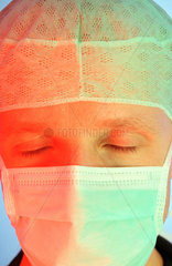 Portraitausschnitt eines Arztes mit Mundschutz und OP-Haube