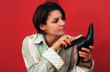 Eine junge Frau putzt Schuhe