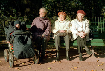 Drei Rentnerinnen sitzen auf einer Parkbank