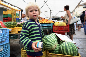 Santanyi  kleiner Junge auf einem Wochenmarkt mit Melonen