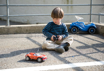 Carabietta  Schweiz  Junge spielt auf einem Parkplatz mit seinem ferngesteuerten Auto