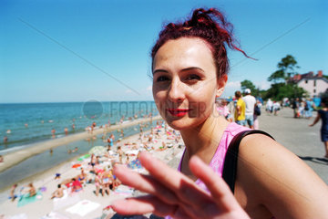 Fotoscheue russische Touristin an der Strandpromenade in Selenogradsk (Cranz)