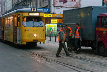 Posen  Polen  Strassenbahn faehrt abends an Arbeitern der Schienenwartung vorbei