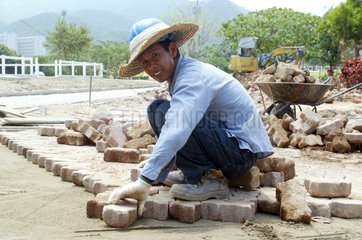 Hong Kong  China  Bauarbeiter verlegt Pflastersteine