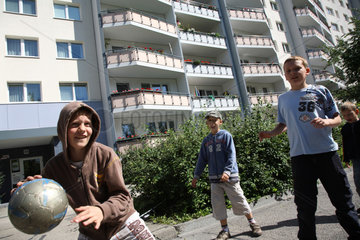 Berlin  Deutschland  Kinder spielen Ball in einer Wohnsiedlung in Marzahn