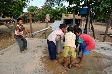 Sre Ambel  Kambodscha  Jungen trinken Wasser aus einem Brunnen