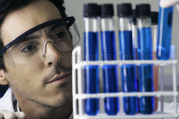 Researcher scrutinizing test tubes in laboratory