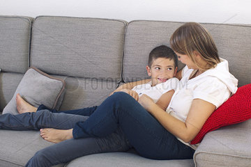 Mother and son relaxing together on sofa