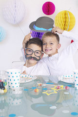 Boys wearing funny disguises at birthday party