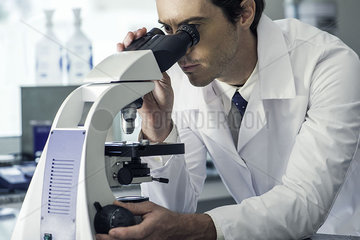 Biologist using microscope
