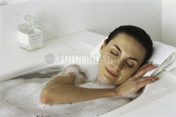 Woman soaking in bath  eyes closed