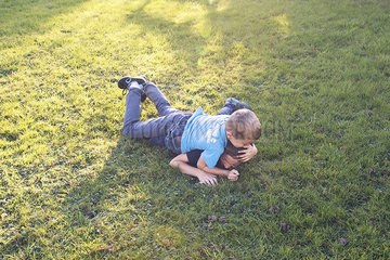 Boys wrestling on lawn