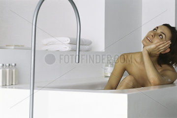 Woman sitting in bath  daydreaming