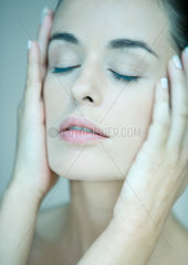 Woman  eyes closed and hands on side of face  portrait