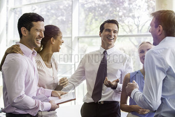 Colleagues having laugh together in office