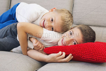 Young brothers lying together on sofa