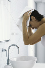 Woman in bathroom  drying hair with towel