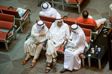Kuwait-Stadt  Kuwait  drei Maenner diskutieren in der Boerse