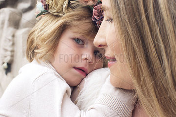 Little girl resting her head on her mother's shoulder